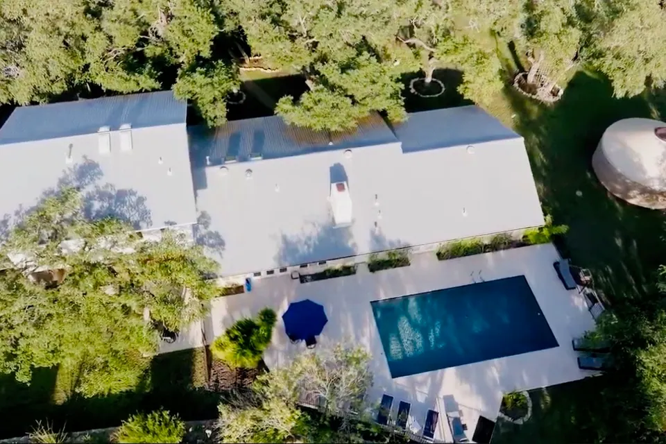 Aerial view of the Retreat House, pool deck and surrounding oaks