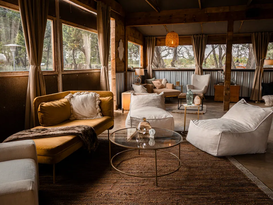 The temple lounge, with sofas and curtained windows looking out to the oaks