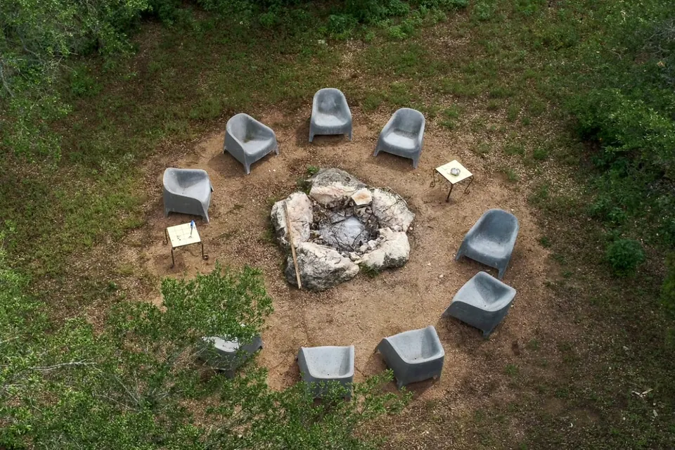 The stone fire pit and its circle of chairs near the yurts